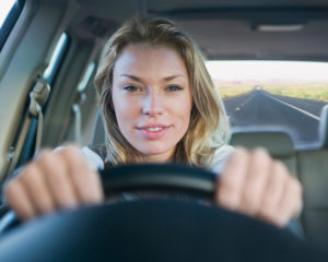 A woman driving down a long road