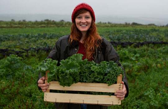 A farmer holding some of her crop.