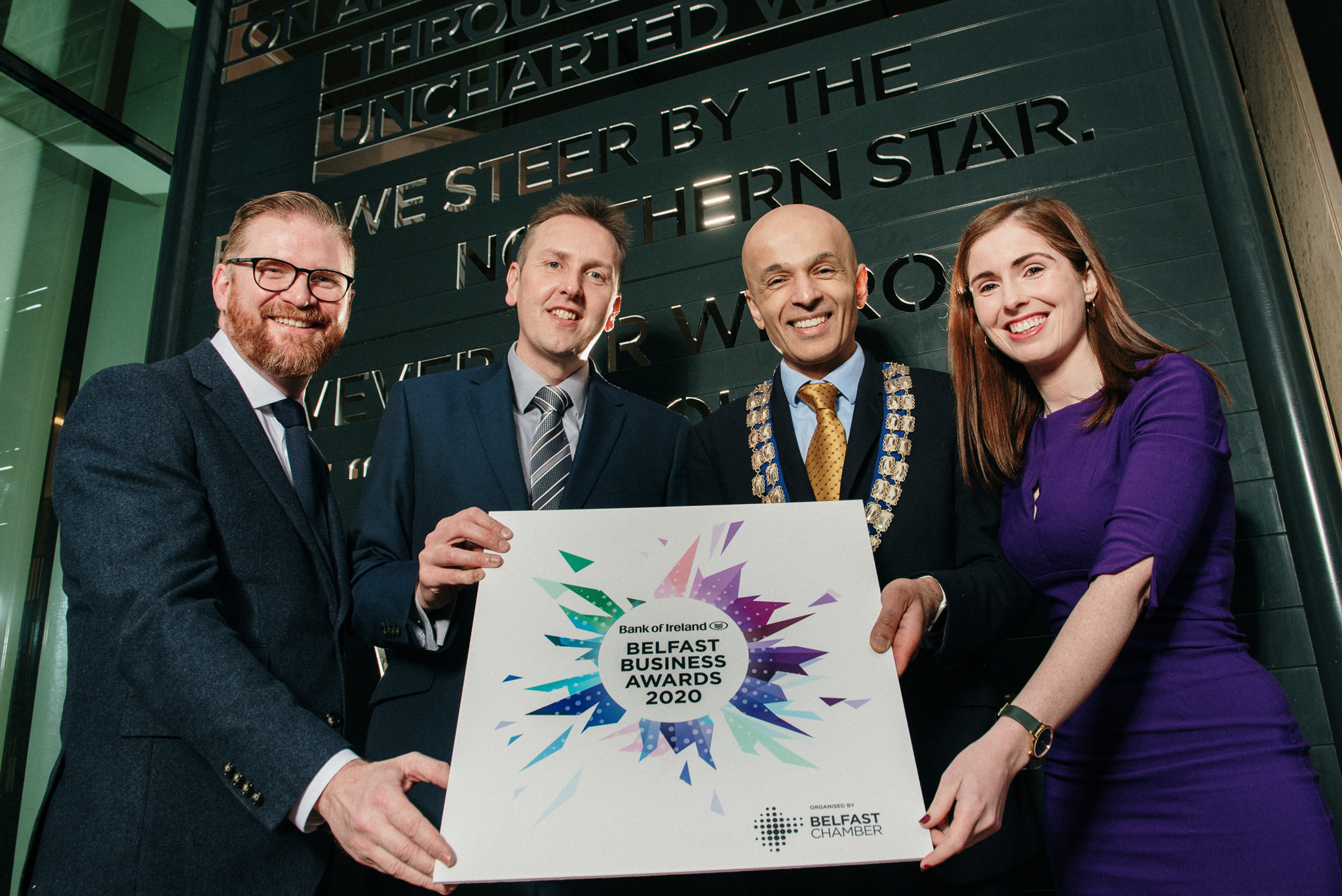 A group of people holding a Belfast Business Award 2020 sign